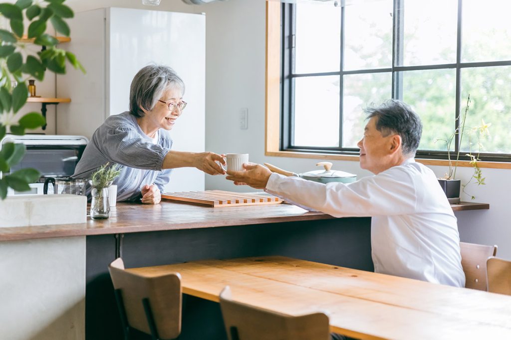 東京都 港区 麻布十番 ネクスト・アイズ|家のキッチンでコーヒーをいれる高齢者女性と高齢者男性（老夫婦）